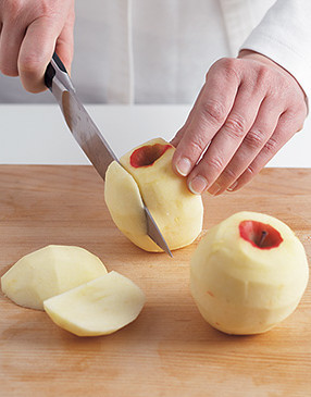 To core an apple, stand it on its blossom end and slice off the four lobes around the core.